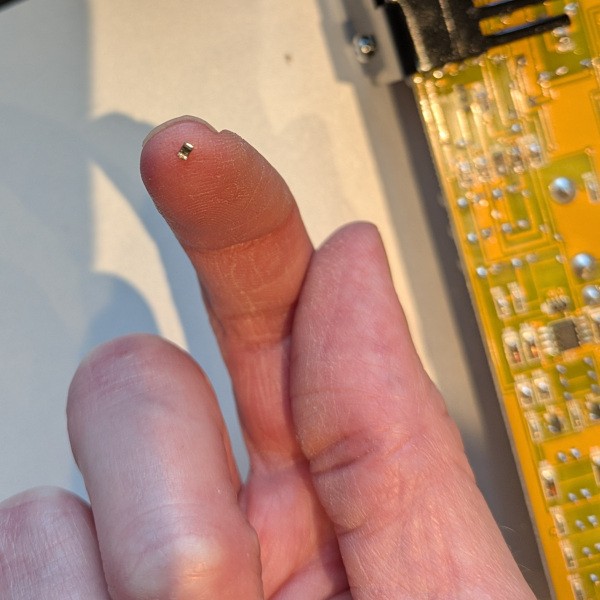 A tiny resistor balanced on the end of a finger